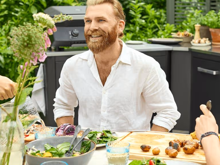 A man sitting at a table with a bowl of salad.