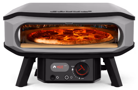 A pizza is cooking in a pizza oven.
