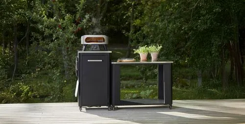 Outdoor table with a pizza oven and some herbs