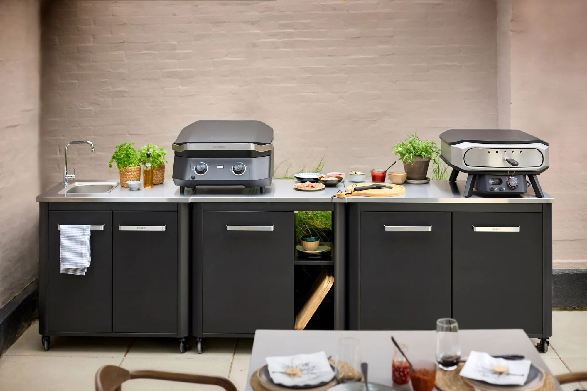 A kitchen with a grill and a table with food on it.