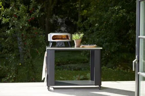 A small table with a toaster oven on top of it.
