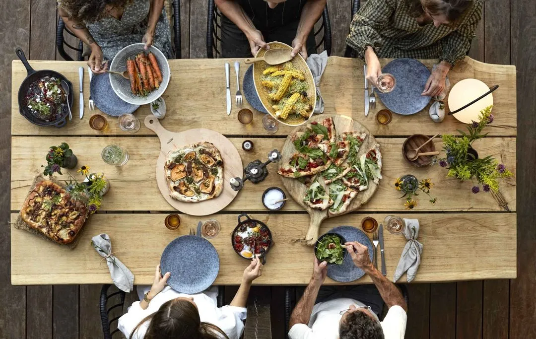 A group of people sitting at a table with plates of food.