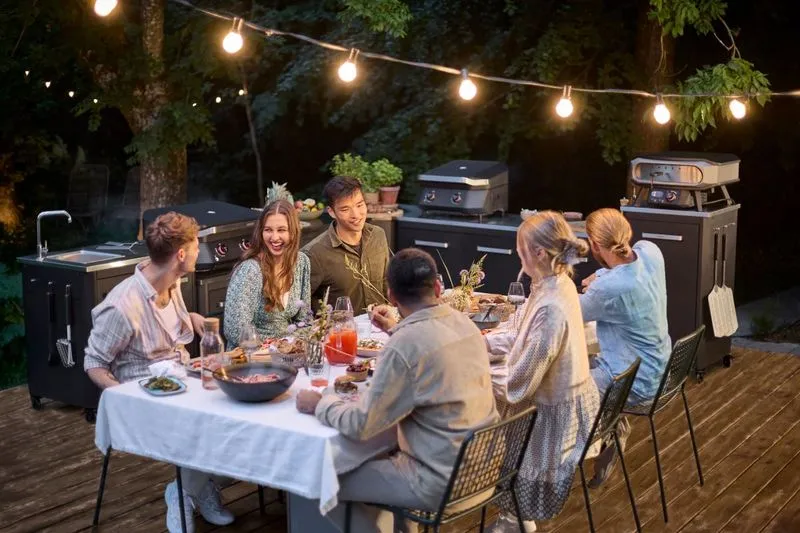 A group of people sitting around a table with food.
