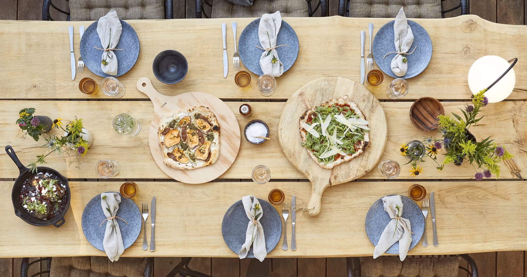 A wooden table topped with plates of food.