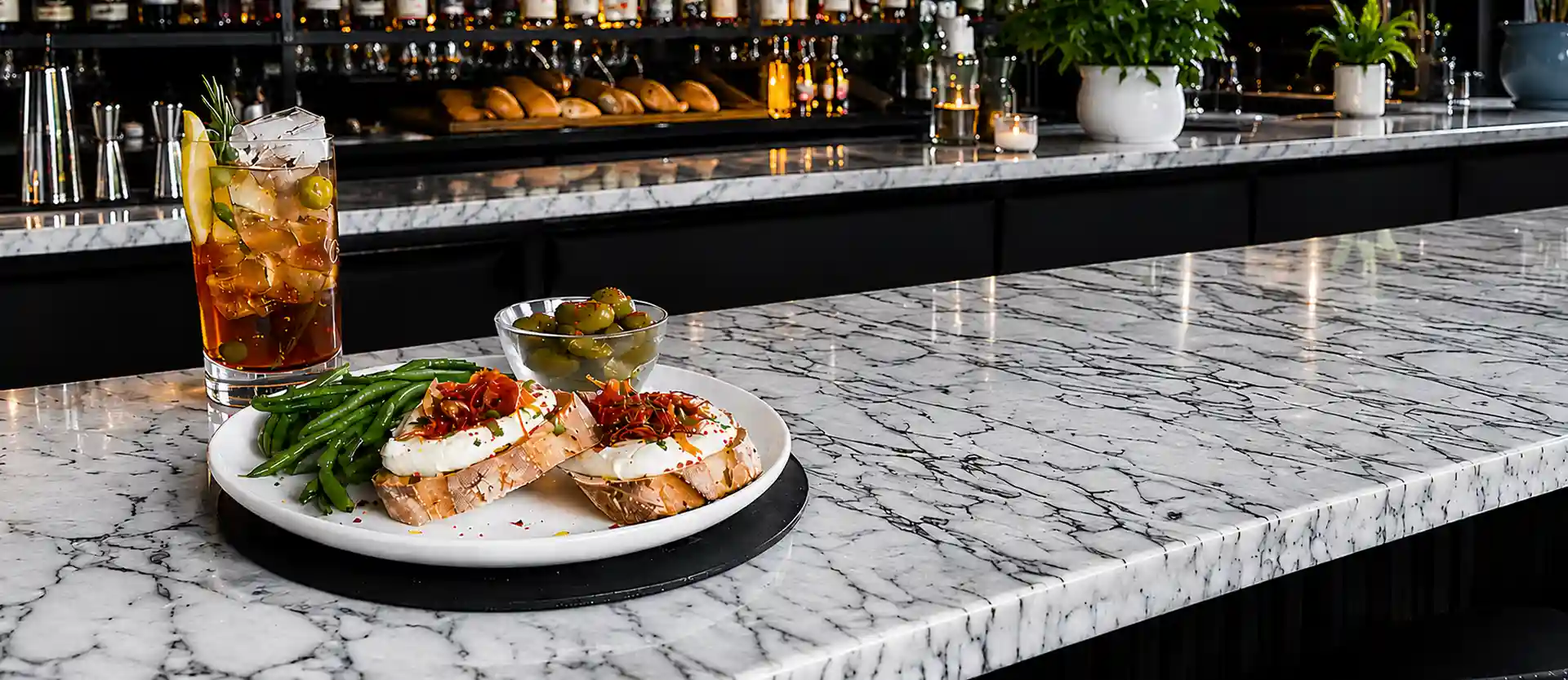 Bruschetta and a cocktail served on a marble bar counter