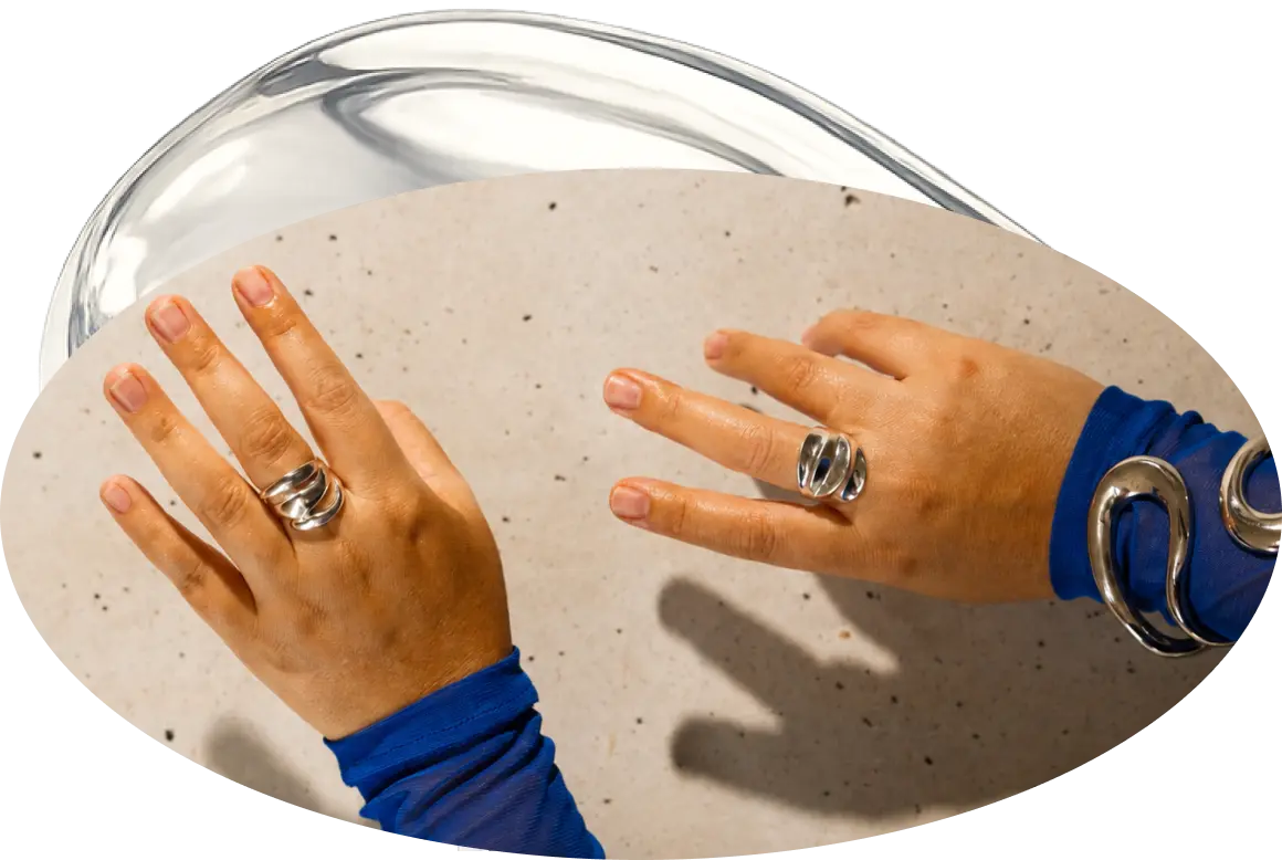 Hands in blue sleeves practicing a movement over a glass bowl