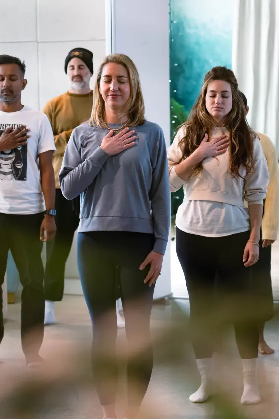 Group practicing a mindfulness exercise with hands on their chests