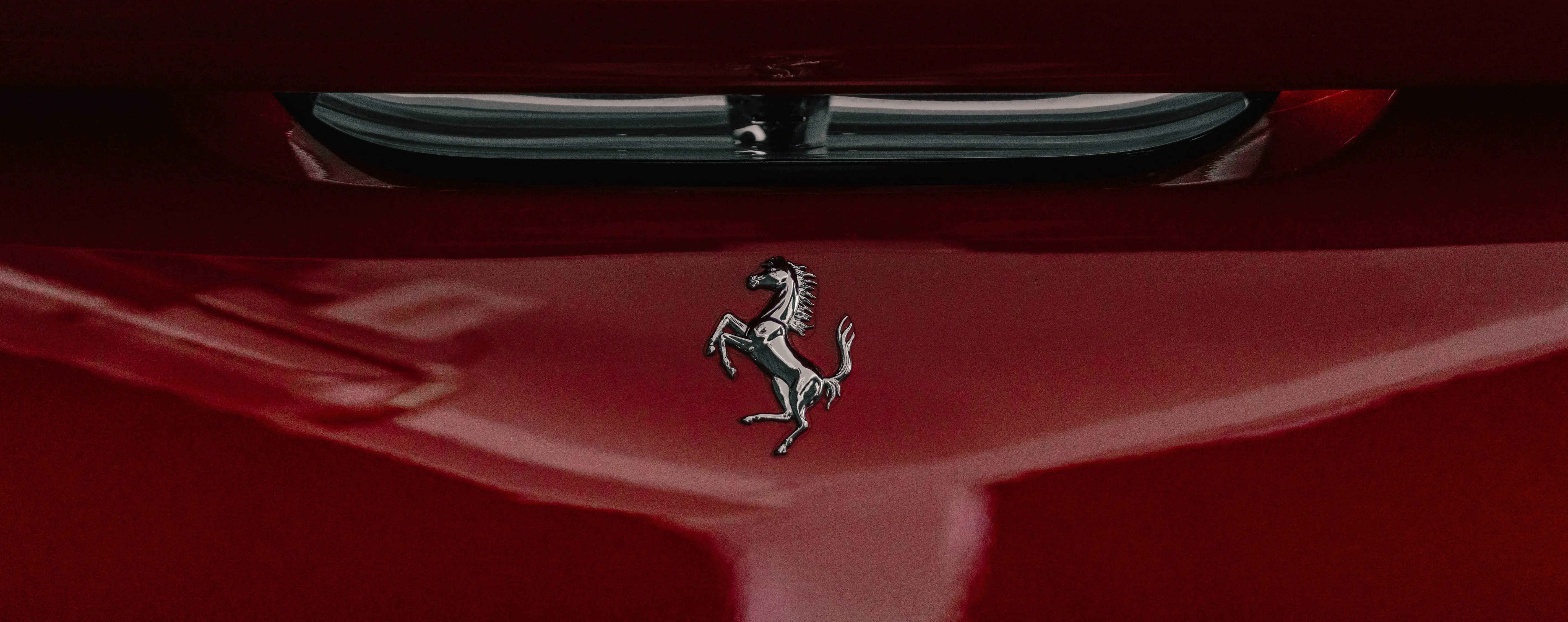 Prancing Horse badge on a red Ferrari bonnet