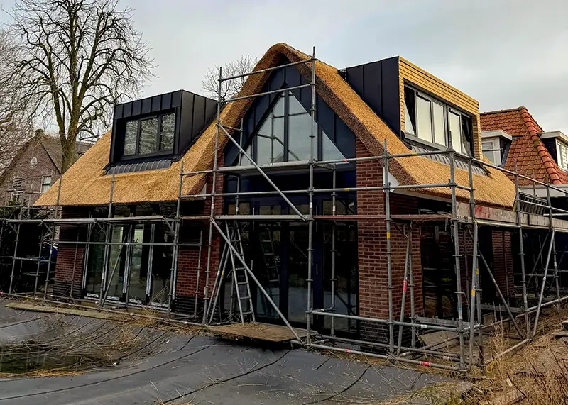 Een modern huis met traditioneel rietgedekt dak.