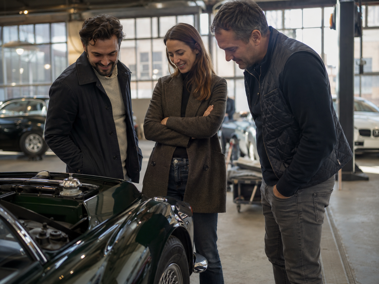 Un vendeur montre une voiture noire à trois clients souriants devant un bâtiment vitré.