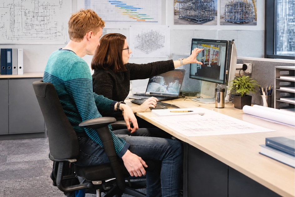 Engineers reviewing a 3D process plant model to support technology scale-up from pilot to commercial scale.