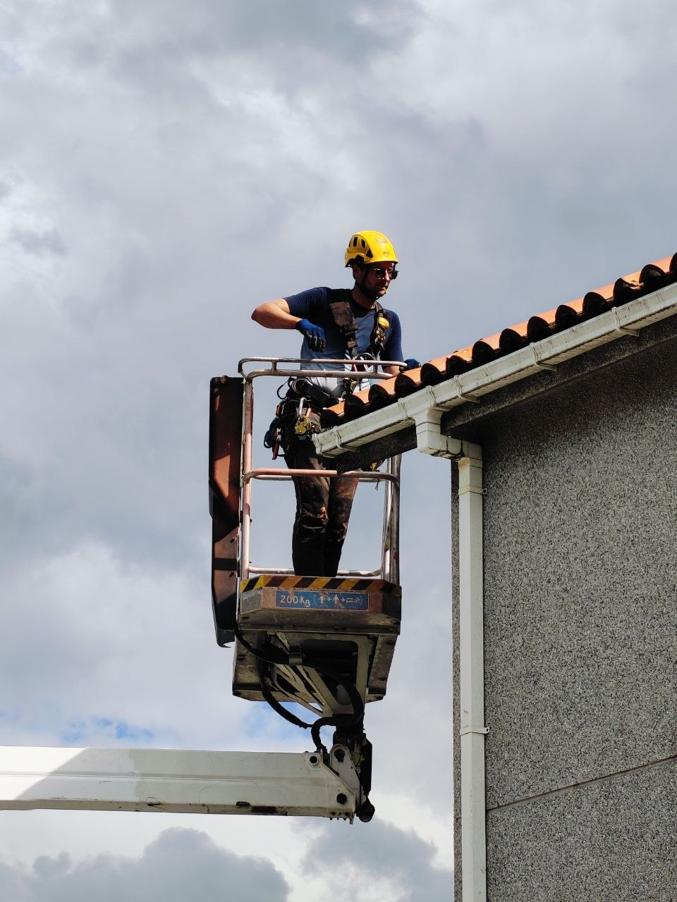Trabajo desde plataforma elevadora junto al alero de una vivienda