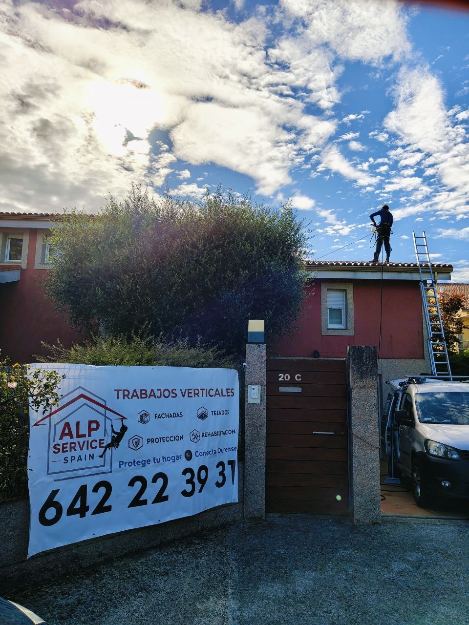 Operario sobre una cubierta junto al vehículo de trabajo