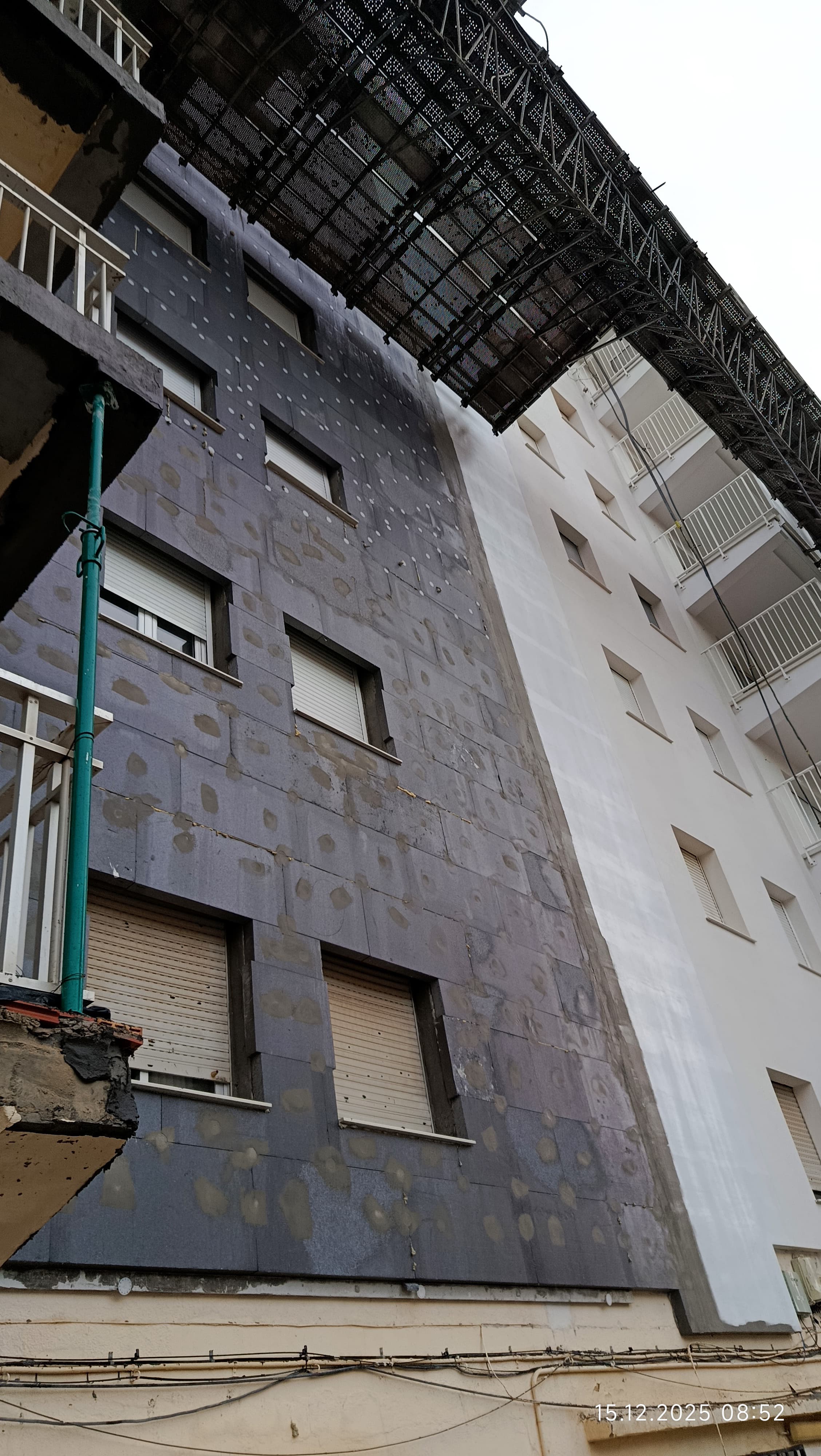 Fachada en preparación con andamios y protección de ventanas