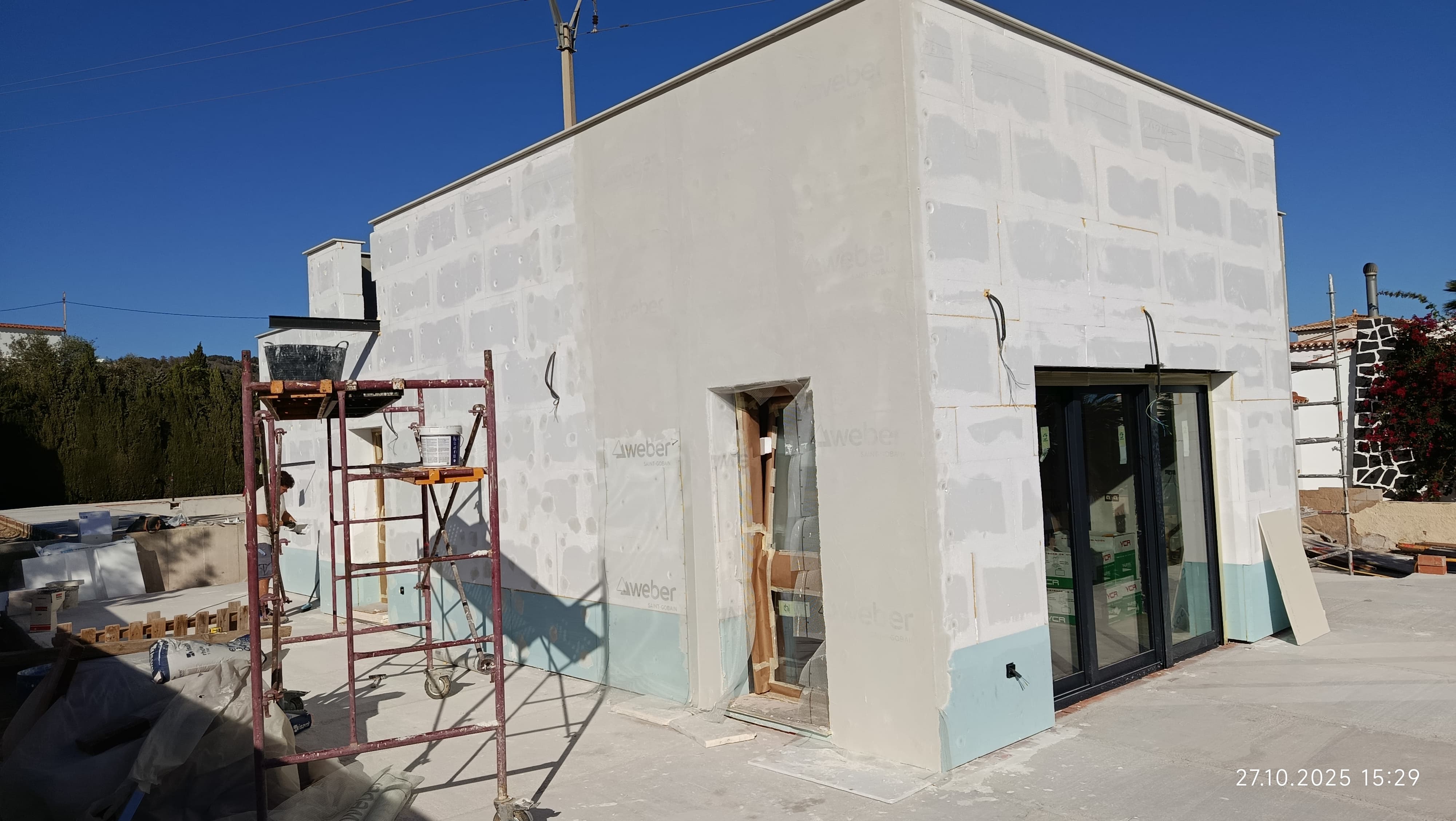 Fachada de una vivienda durante la aplicación del revestimiento