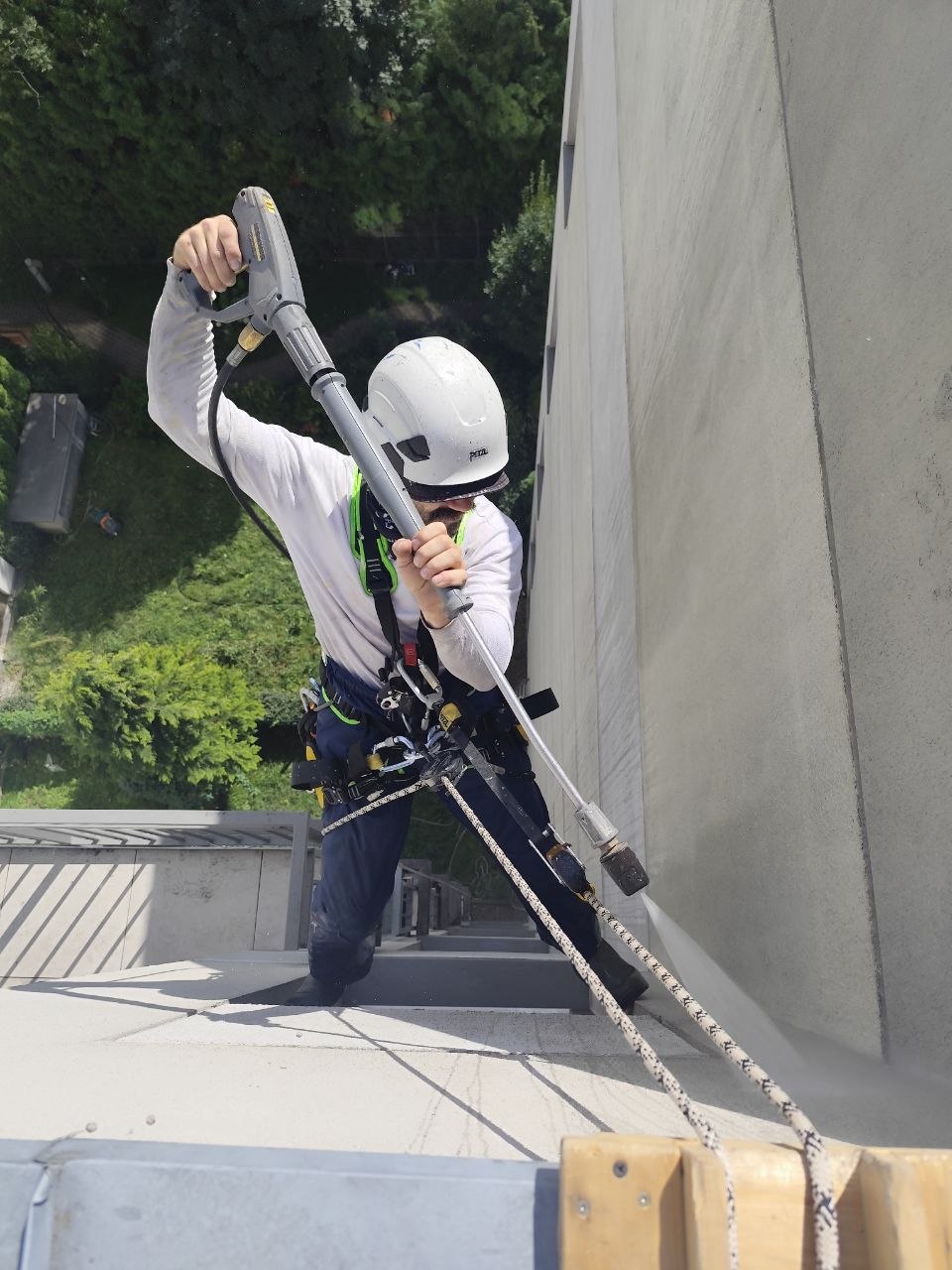 Operario aplicando un tratamiento sobre una pared mediante acceso por cuerdas