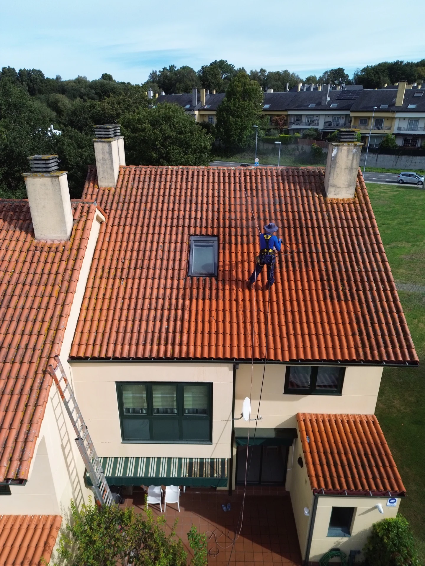 Operario realizando la limpieza del tejado mediante acceso con cuerdas en Vigo