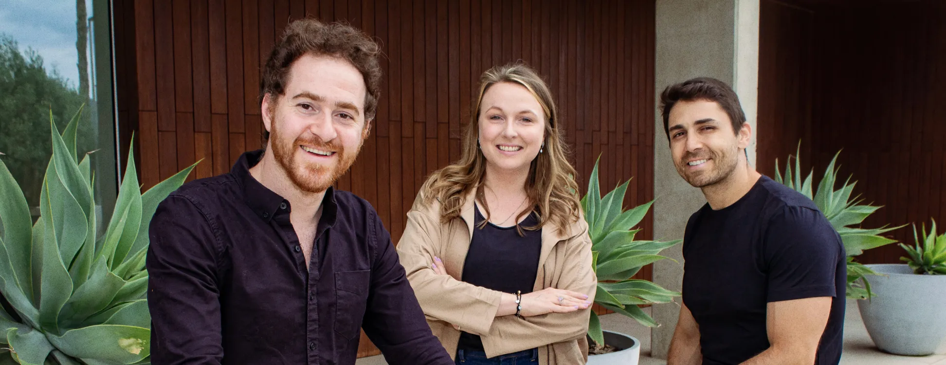 The founders of Unframe in front of a building standing outside.