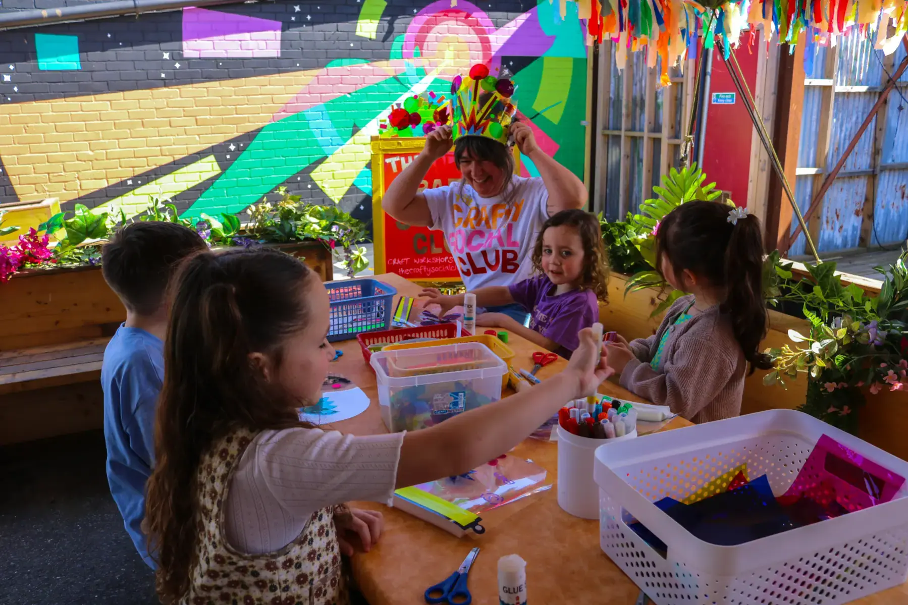 Children making crafts outdoors at a Wake The Tiger free drop-in Craft Session