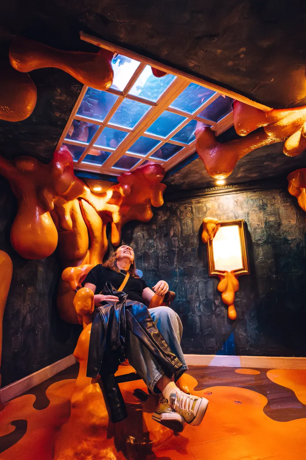 Person sitting inside a surreal orange-themed installation at Wake The Tiger