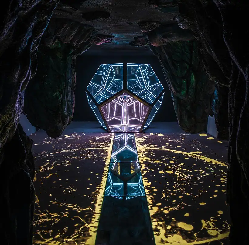 Glowing geometric sculpture inside a dark cave installation at Wake The Tiger.