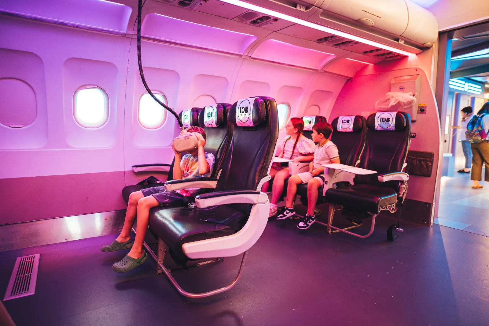 Kids on the aeroplane seats looking through virtual reality headsets at Wake The Tiger