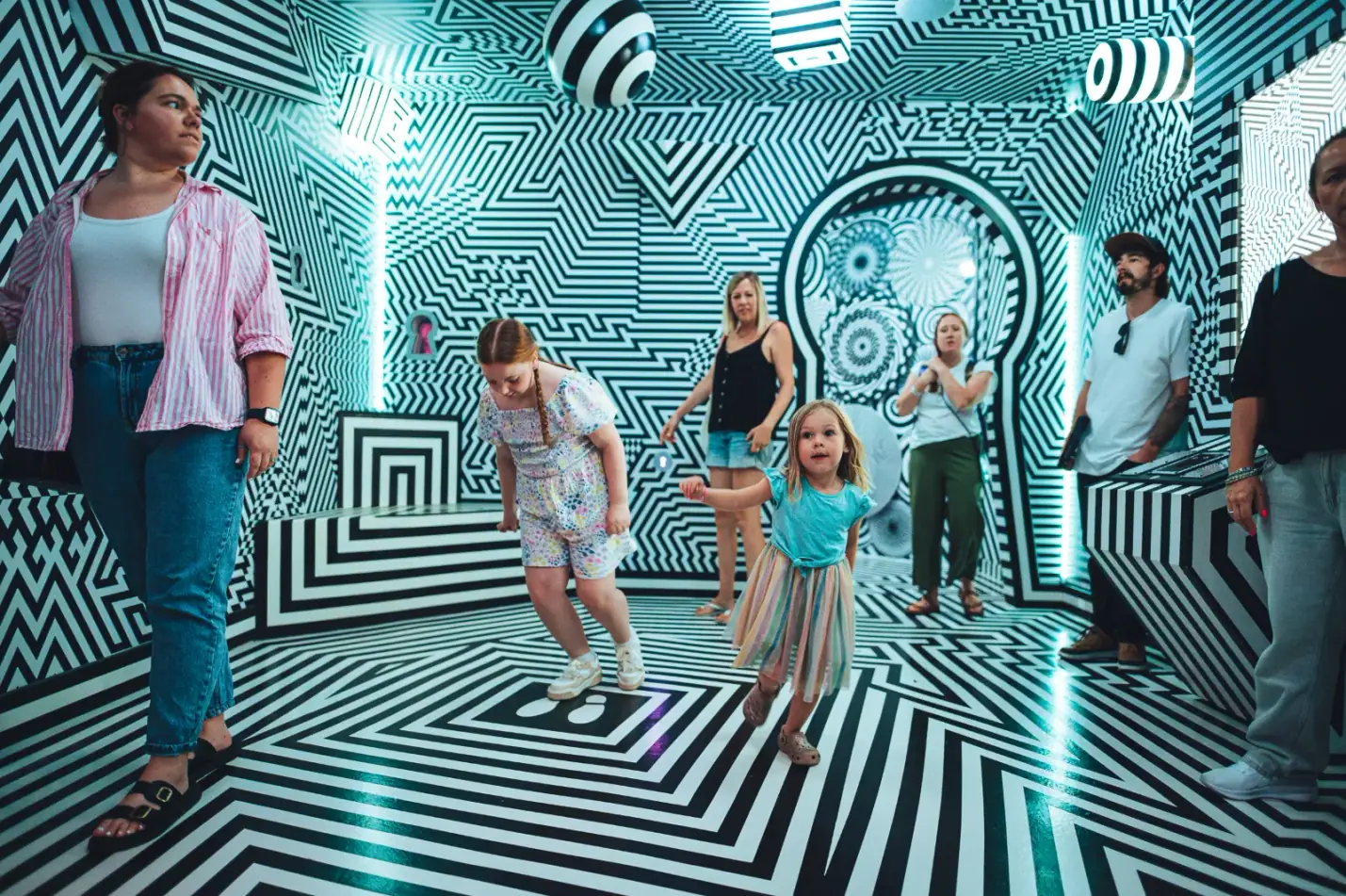 Family exploring an optical illusion room at Wake The Tiger