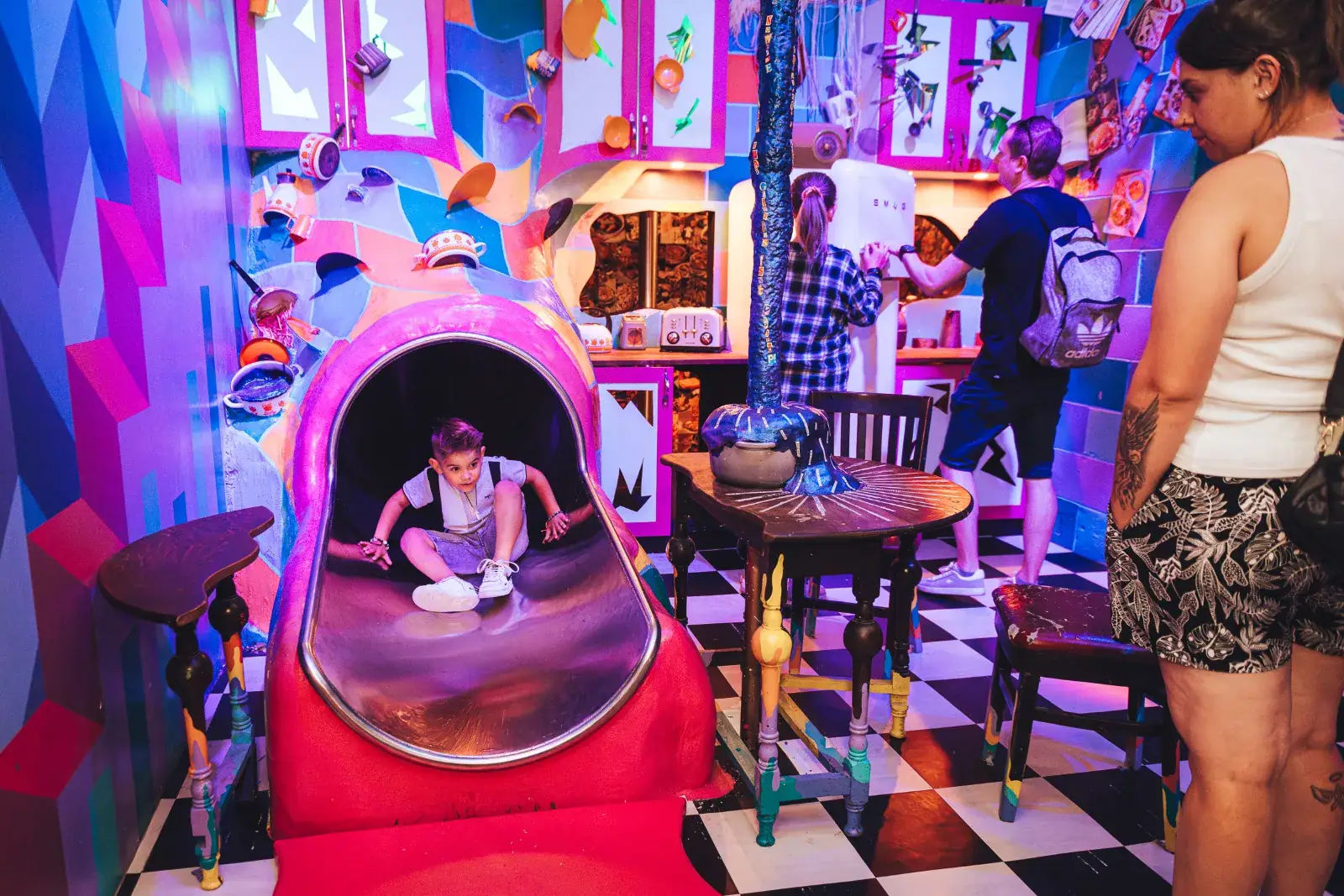 Young boy going down the slide inside a colourful room at Wake The Tiger