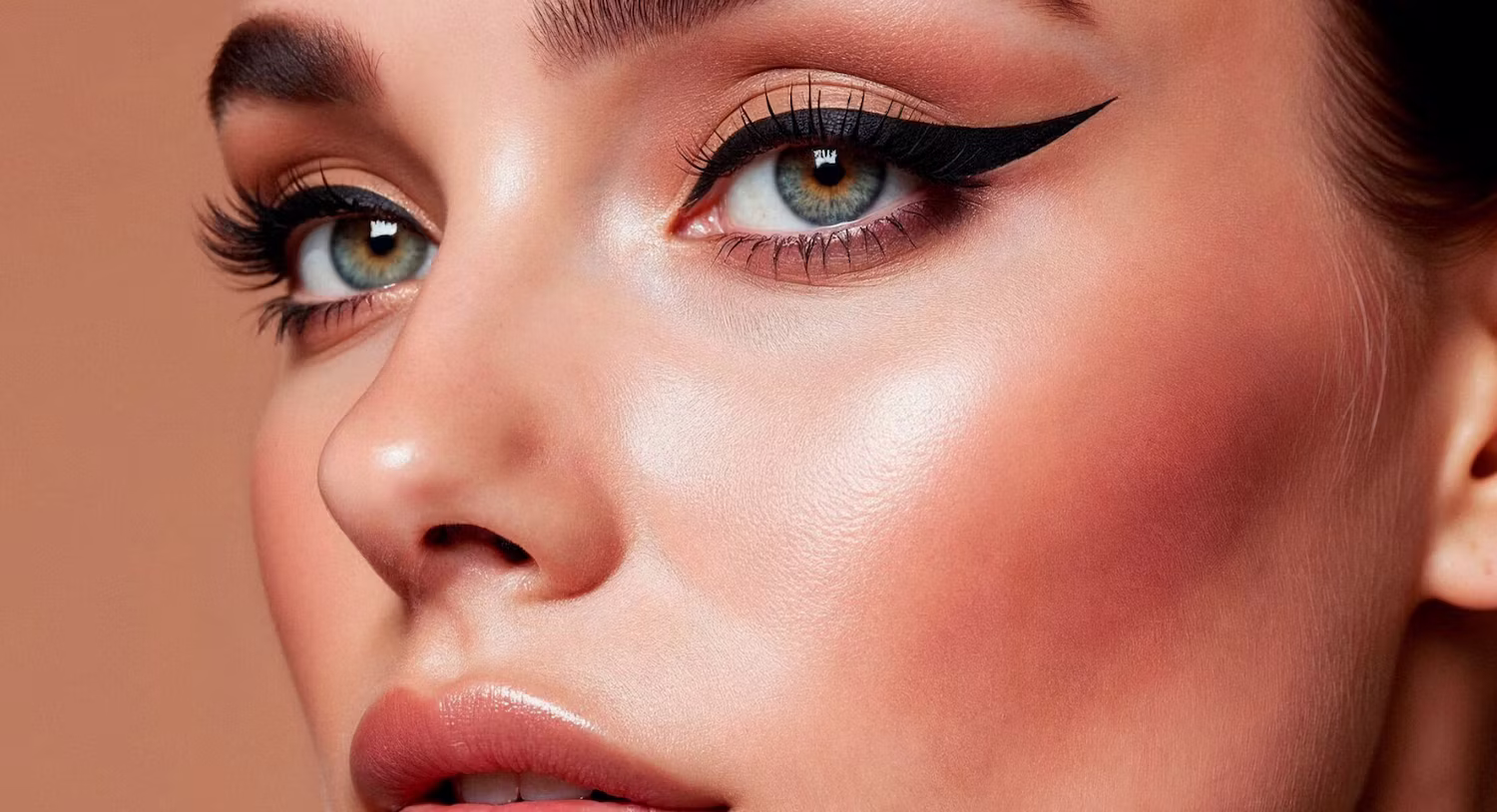 Professional makeup application with winged eyeliner and soft glowing skin