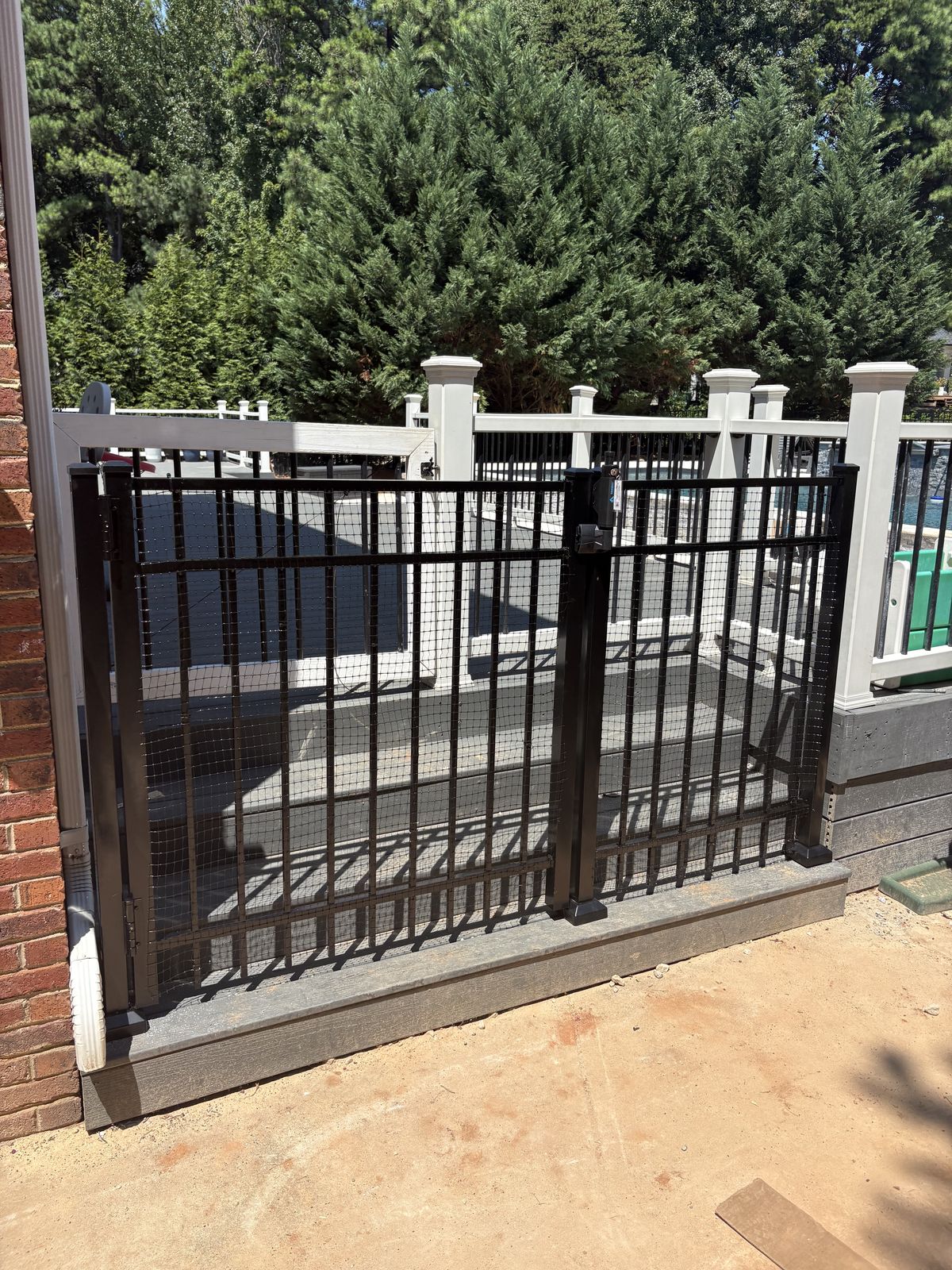 Black aluminum fence installed along wooded backyard property line in Charlotte Metro