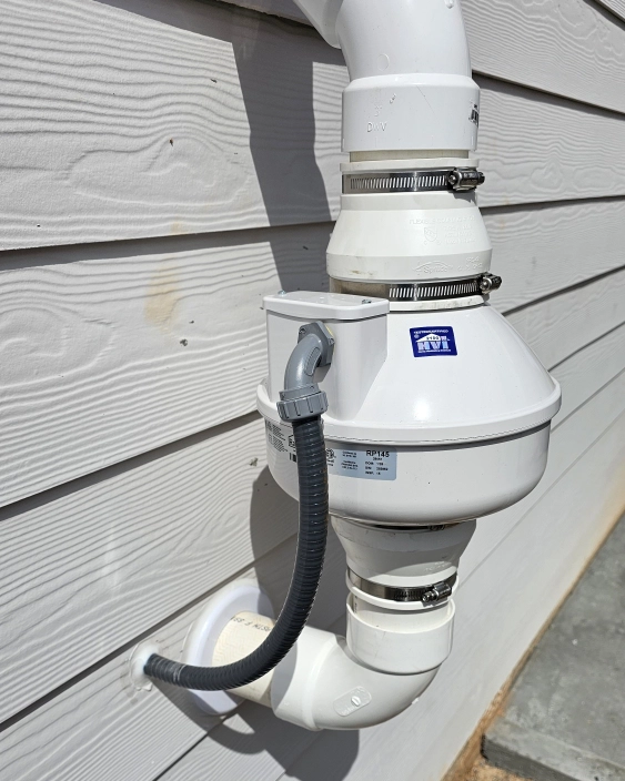 Radon mitigation fan assembly on exterior of home