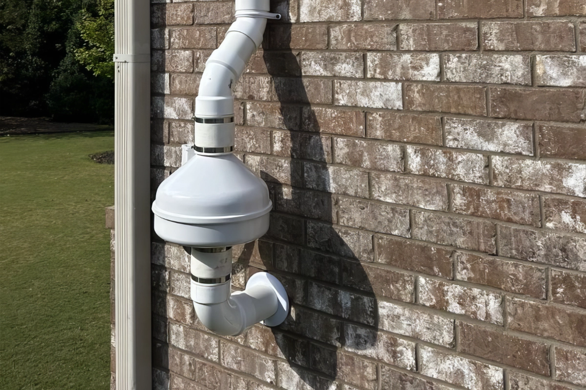 Radon mitigation fan installed on side of a home