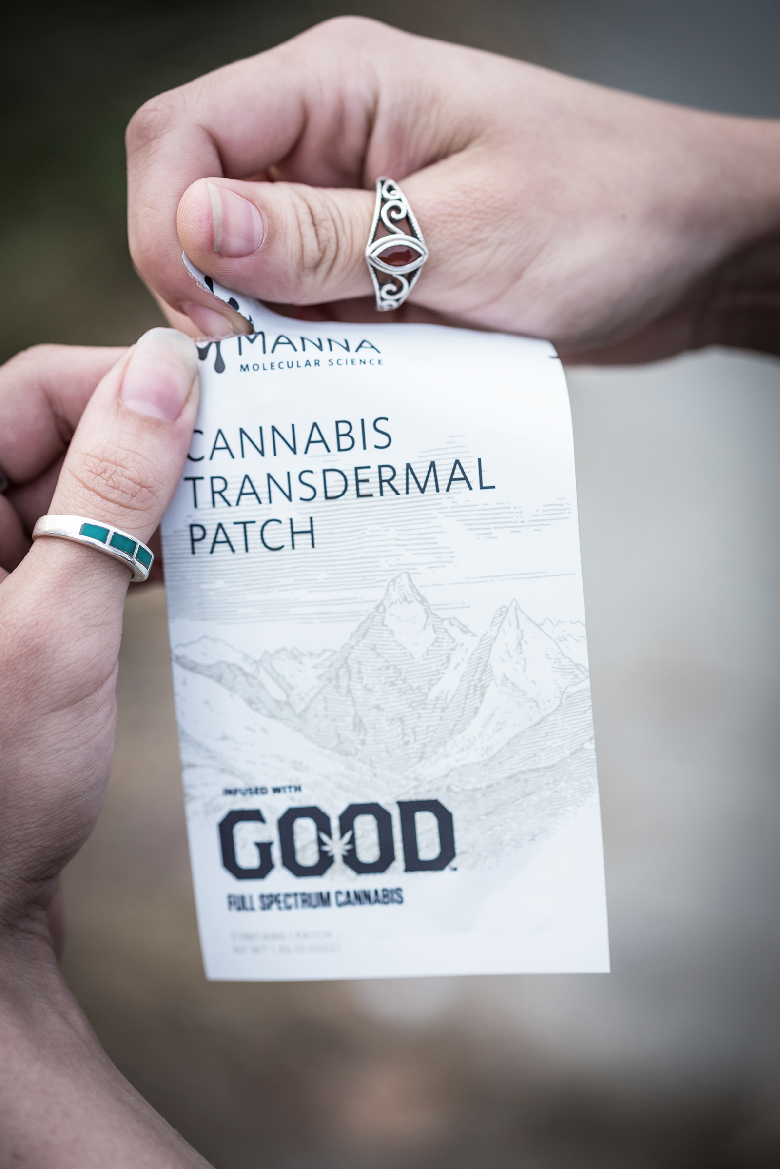 Hands opening a GOOD Patch cannabis transdermal patch pouch