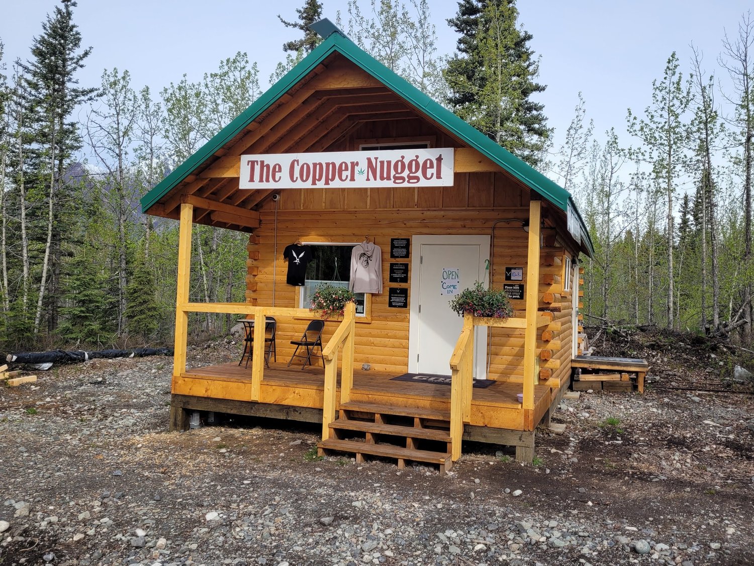 The Copper Nugget shop exterior, a log cabin with teal roof near McCarthy