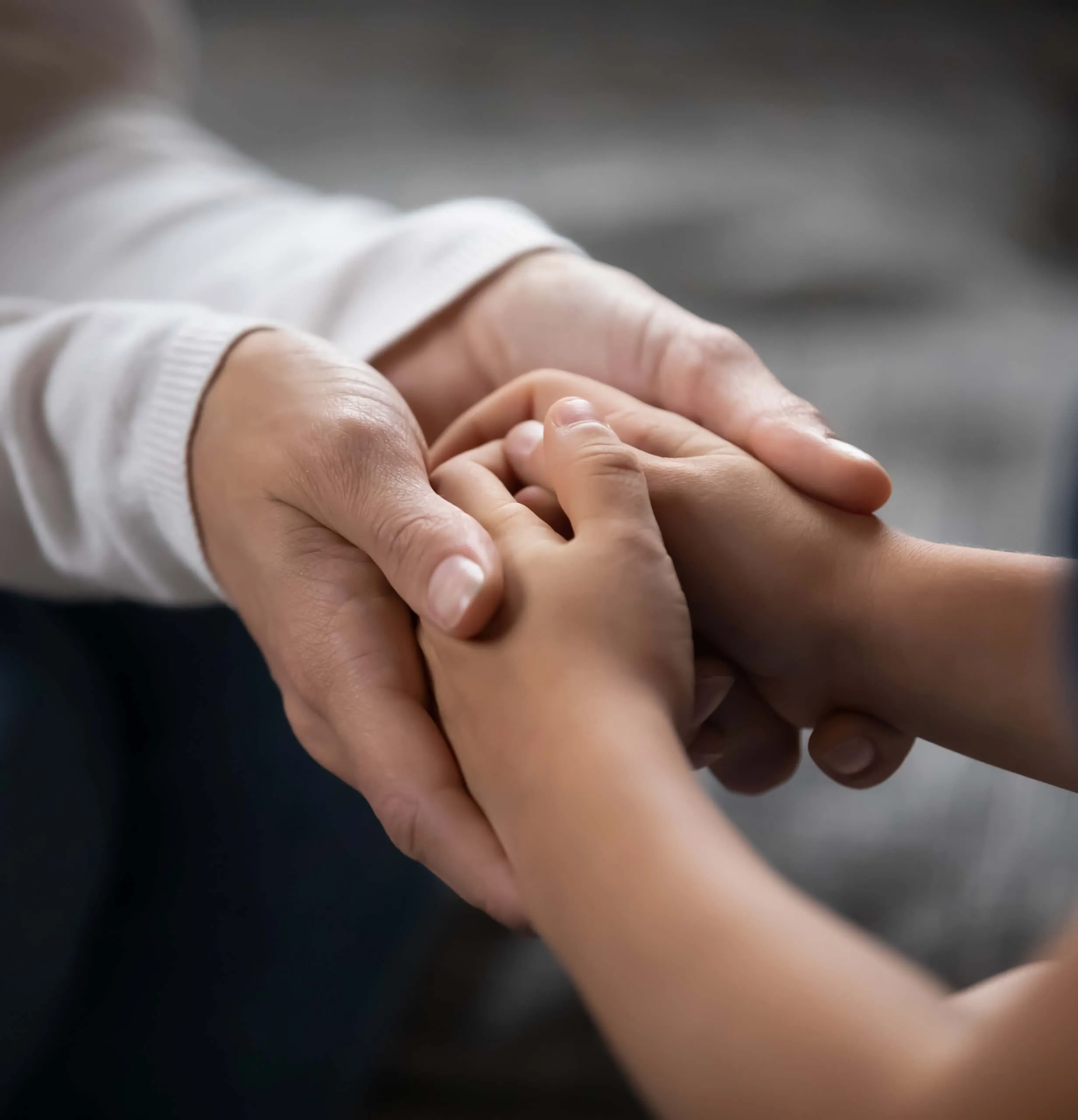 A close up of a person holding a child's hand