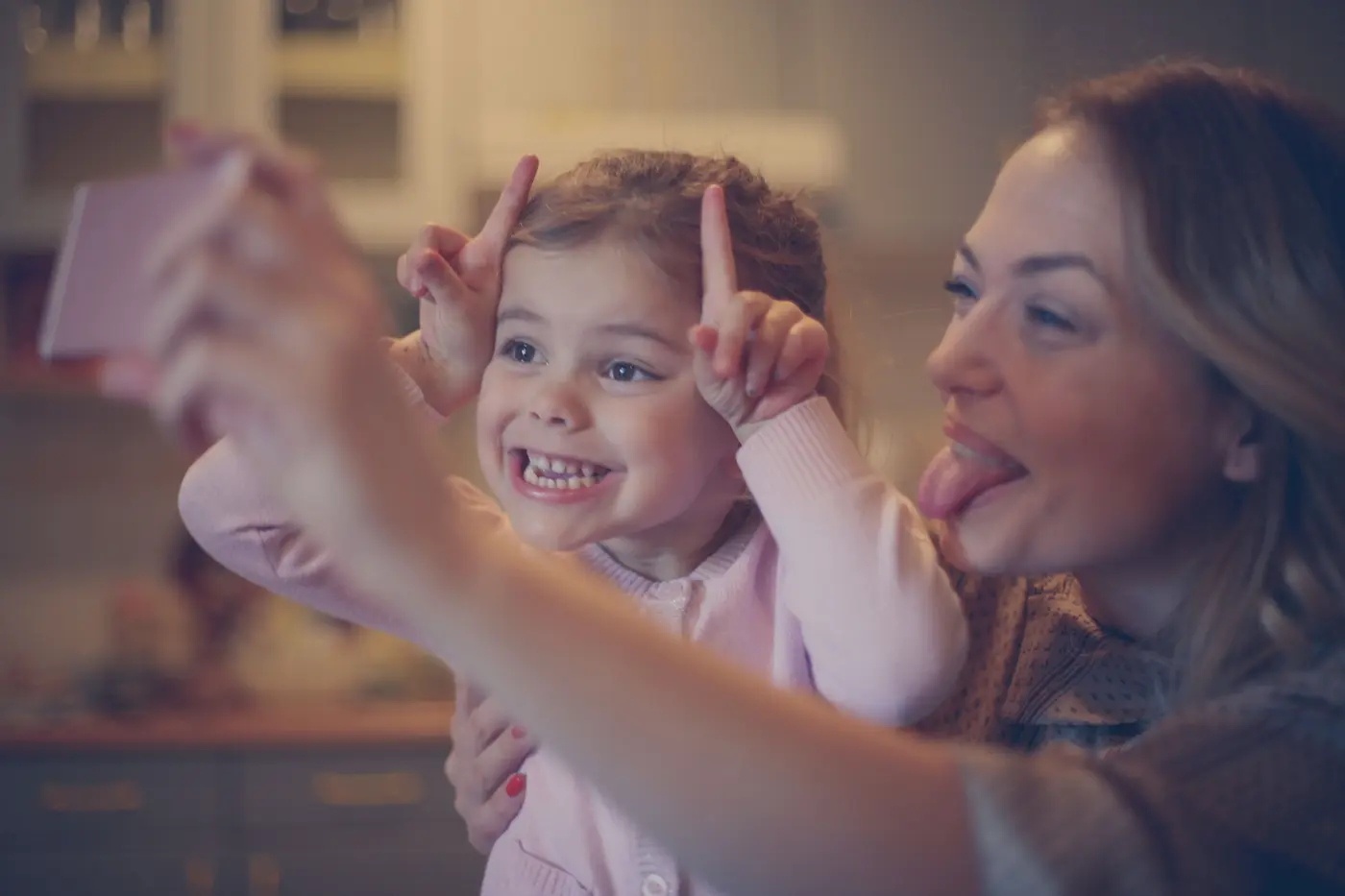 A mother takes a silly selfie with her daughter