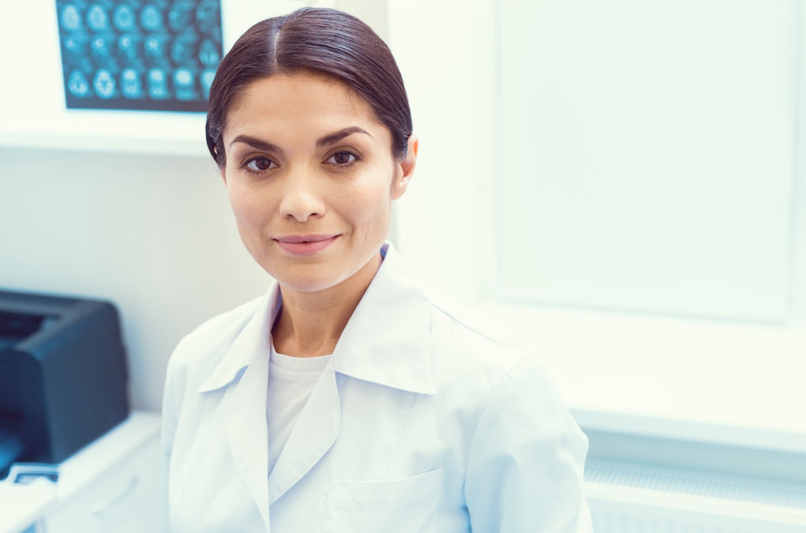 Medical practitioner with light brown hair wearing a white lab coat