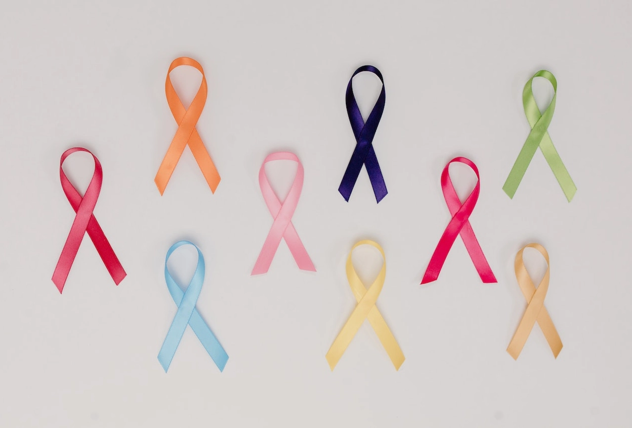 Nine multicolored awareness ribbons displayed on gray background representing various health causes