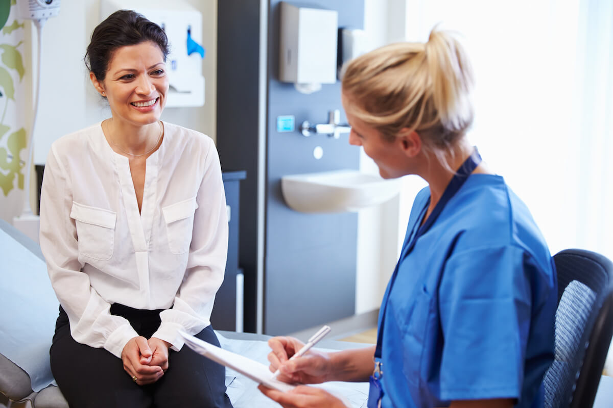 Symptoms of spinal cancer: patient talking to a nurse