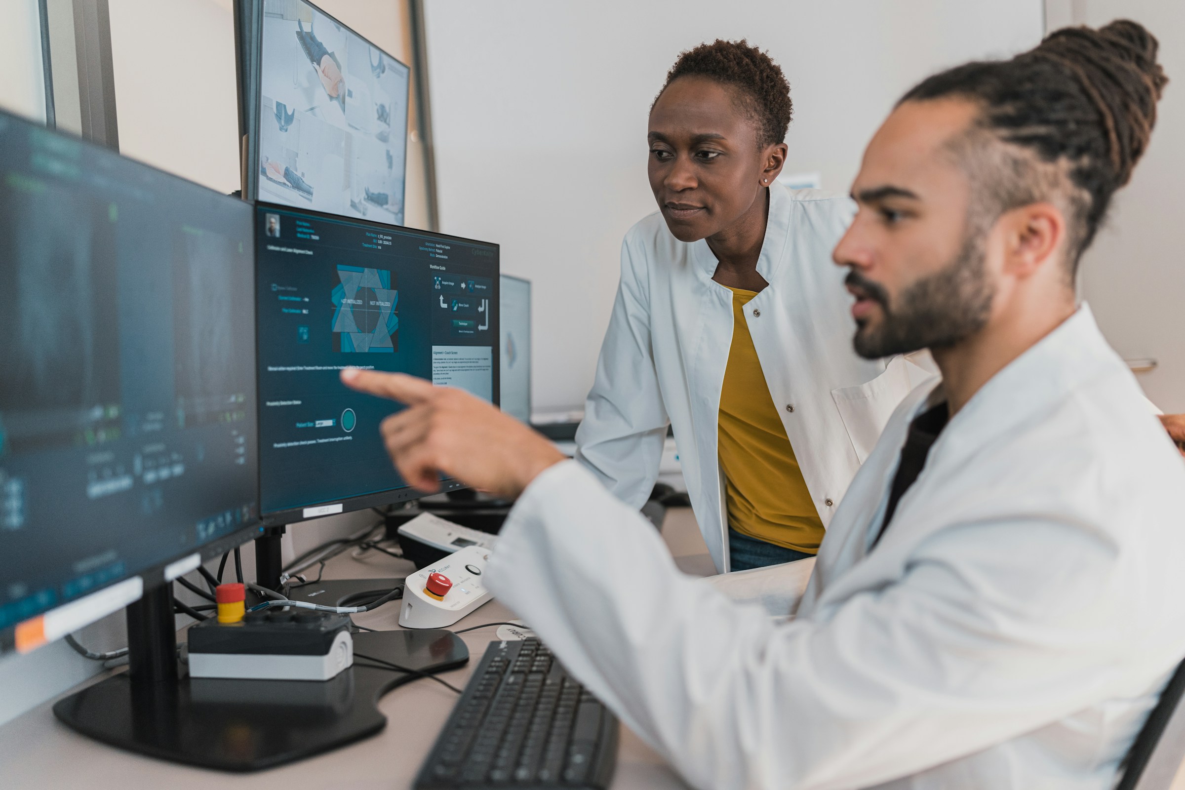 Two medical practitioners observing an MRI taking place.