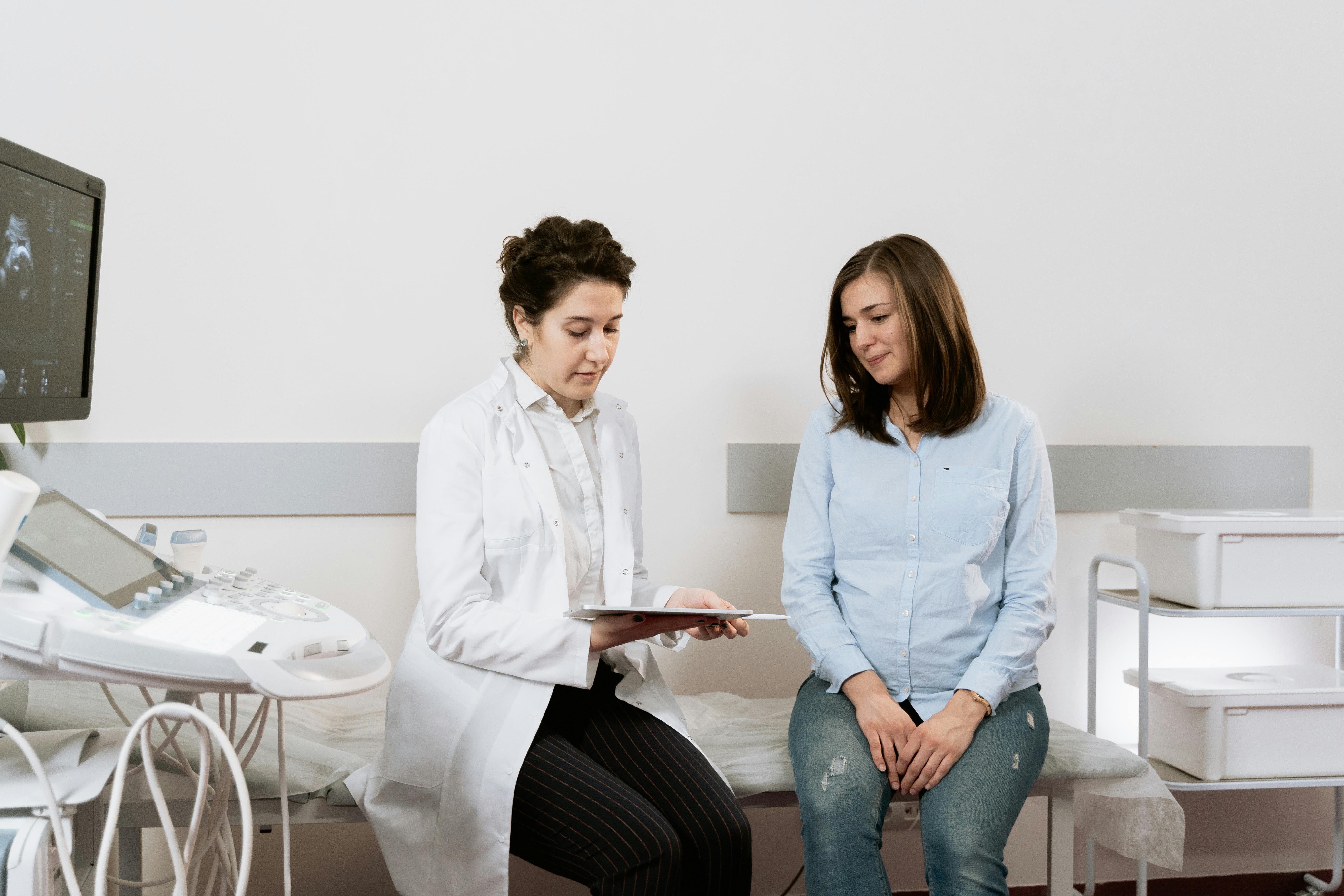 A medical practitioner showing a woman her ultrasound results.