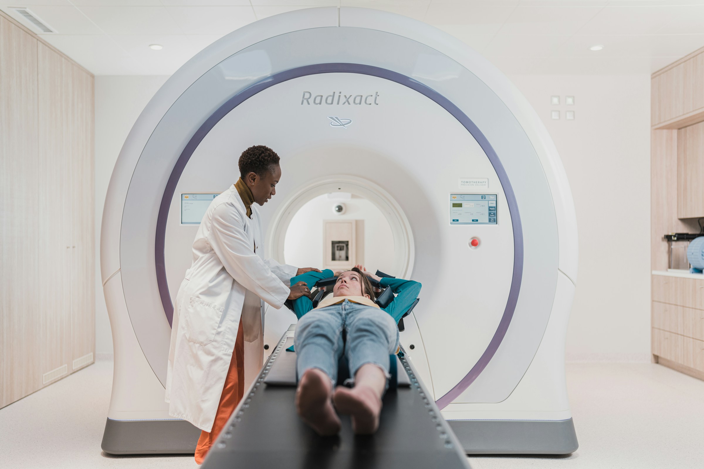 Woman being prepared for a CT by a medical practitioner.