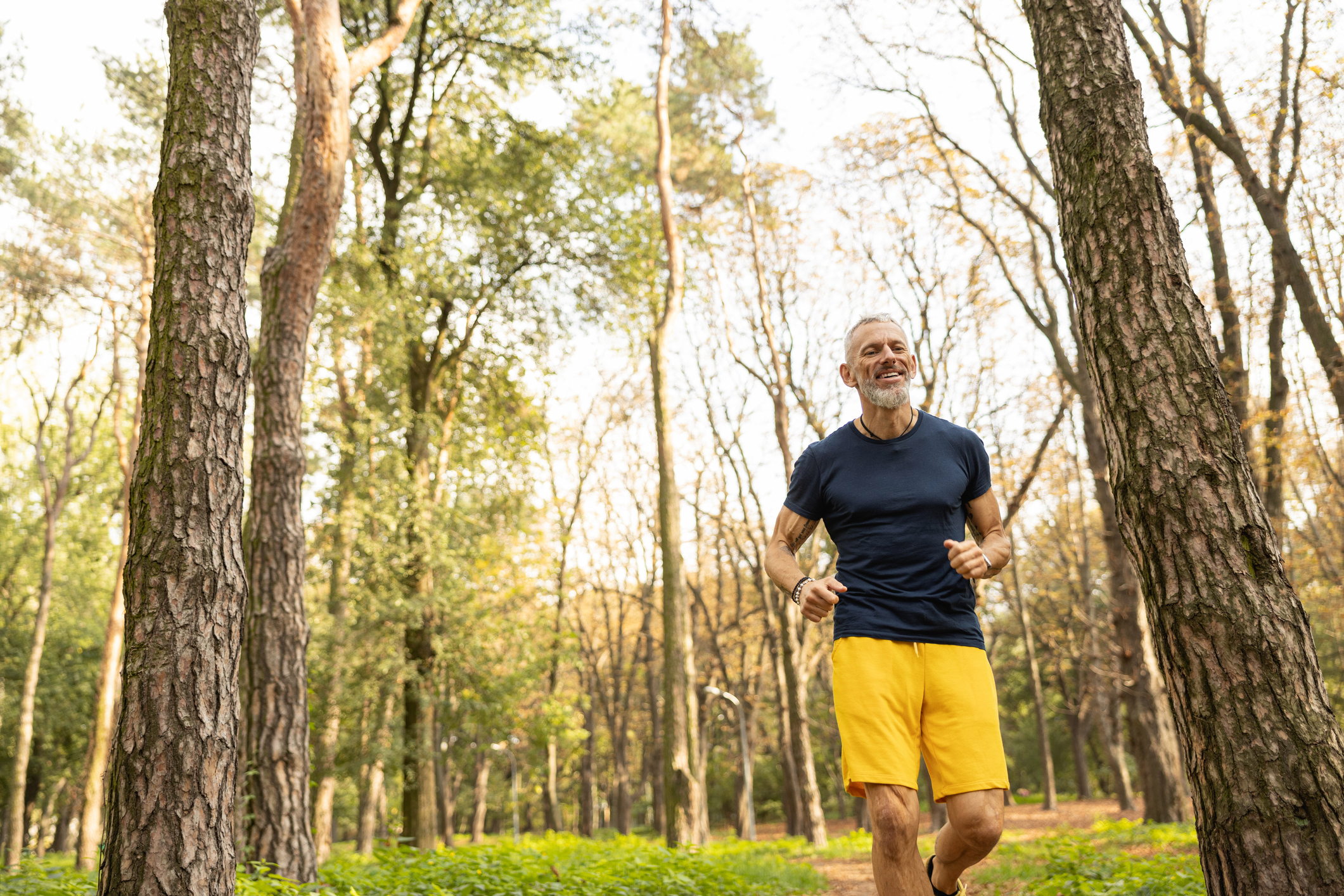 Happy man enjoying a jog through the forest