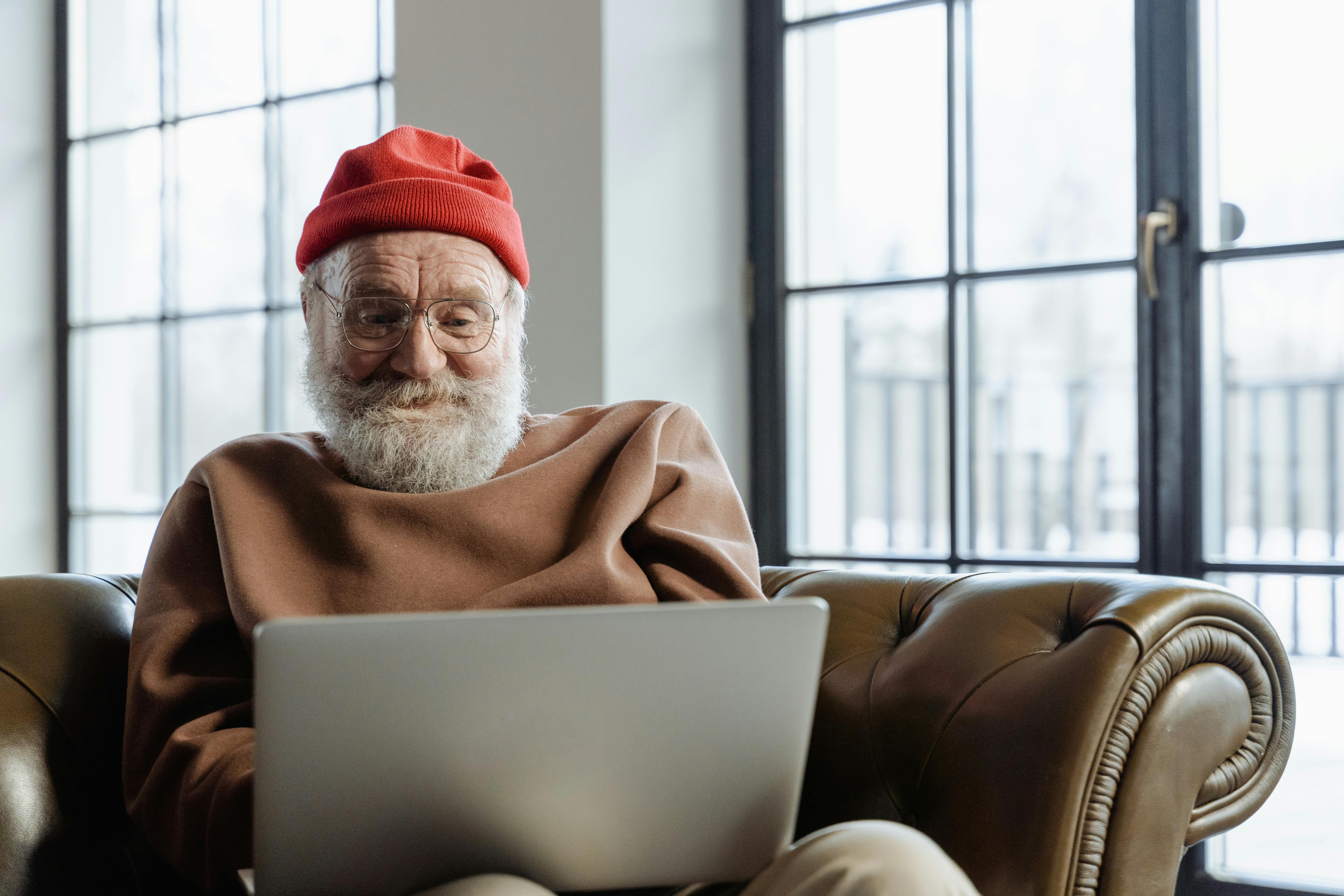 Patient sitting on the couch looking at their laptop
