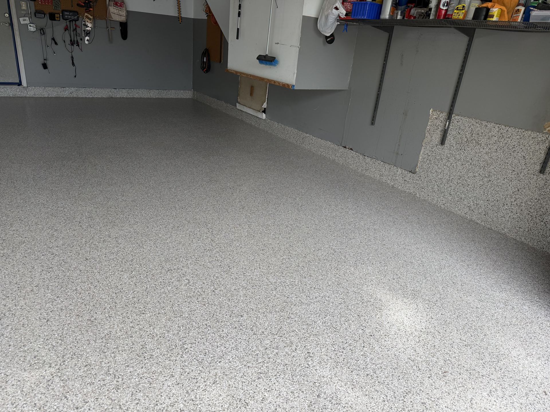 Newly coated speckled epoxy flake floor in a clean, organized garage space.