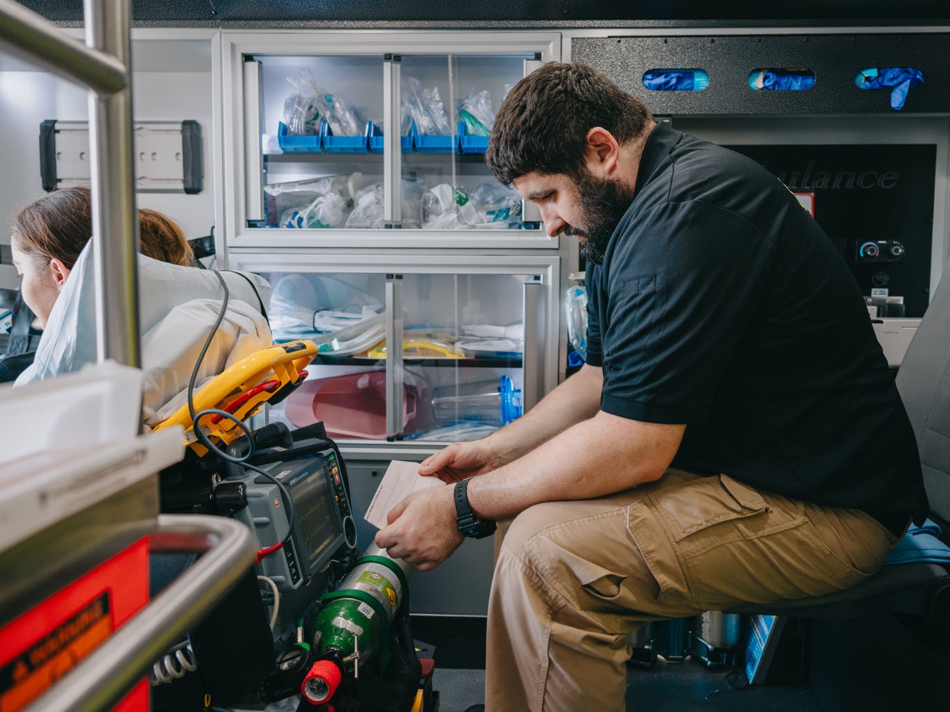 Stark County paramedic working with equipment in an ambulance patient compartment