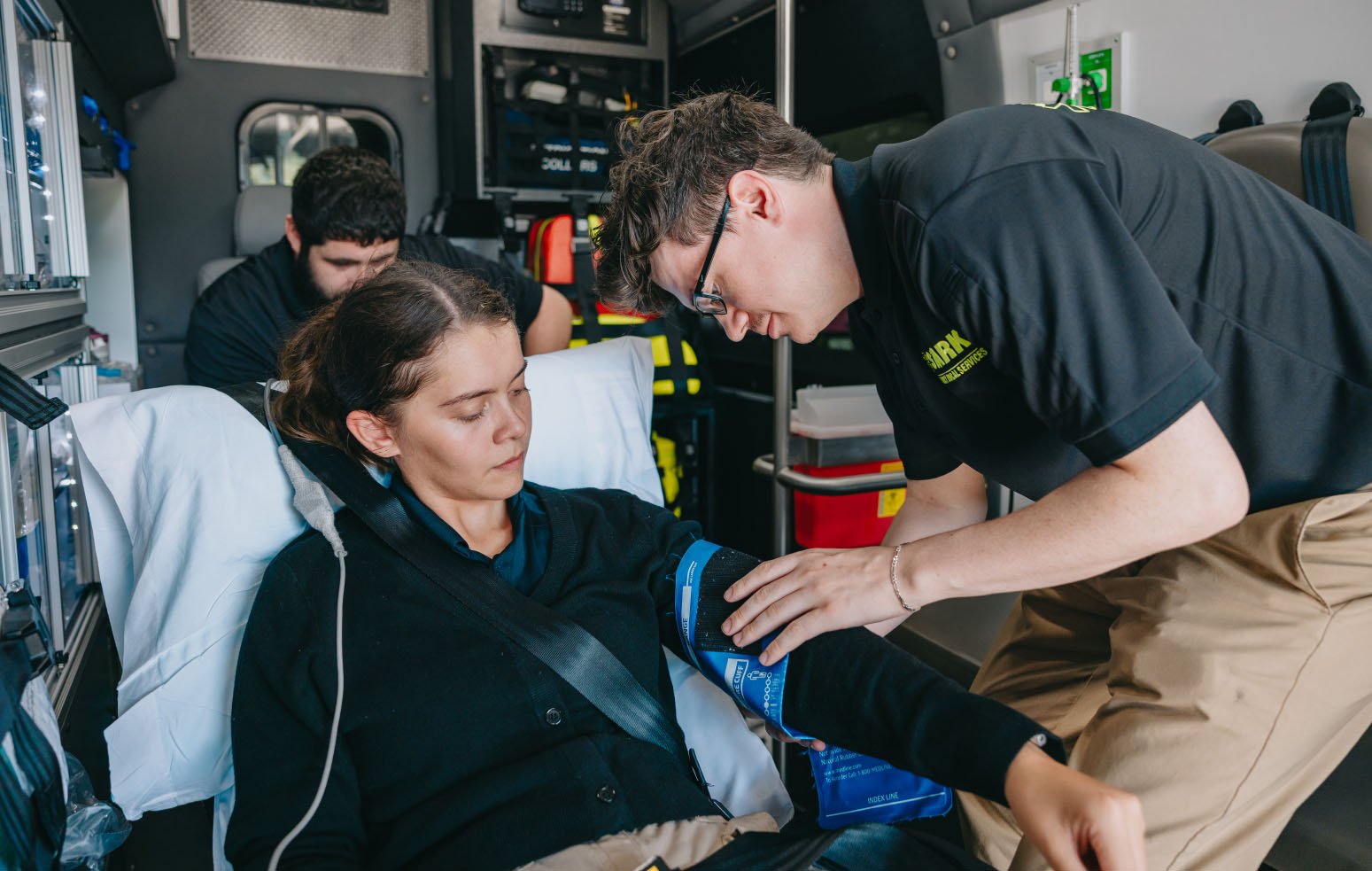Stark County paramedic assessing a patient during transport