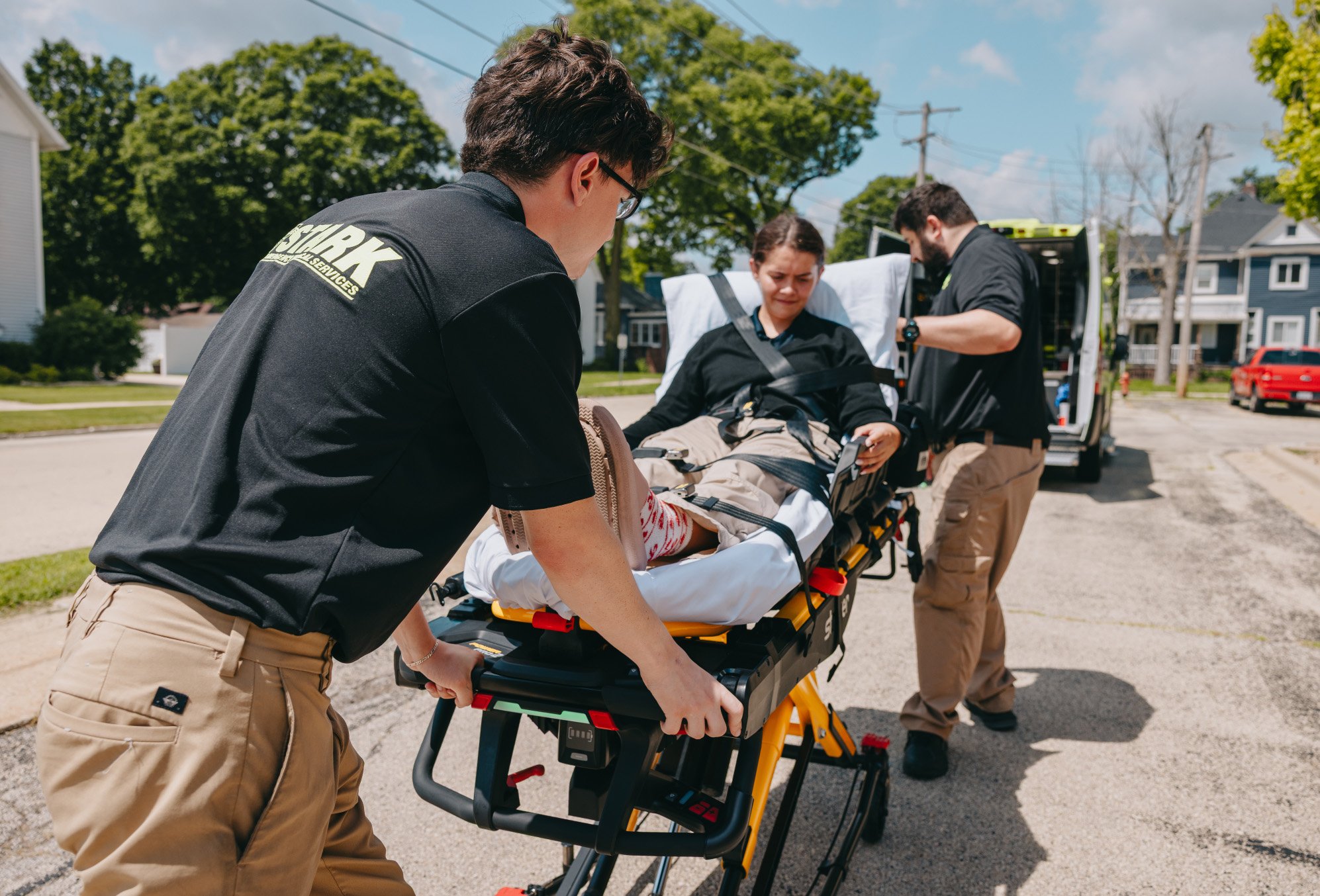 Stark County Ambulance crew moving a patient on a stretcher outdoors