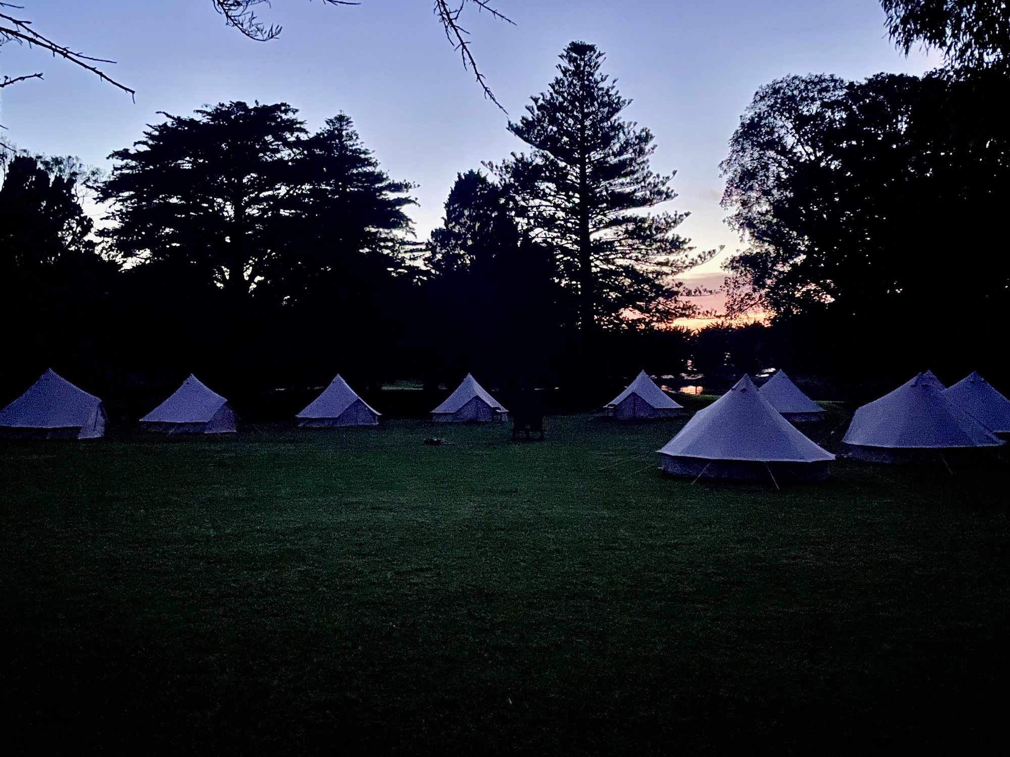 A gathering of tents at dusk