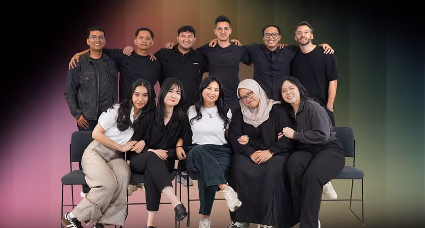 Group of ten diverse young adults smiling and posing together against a gradient background.